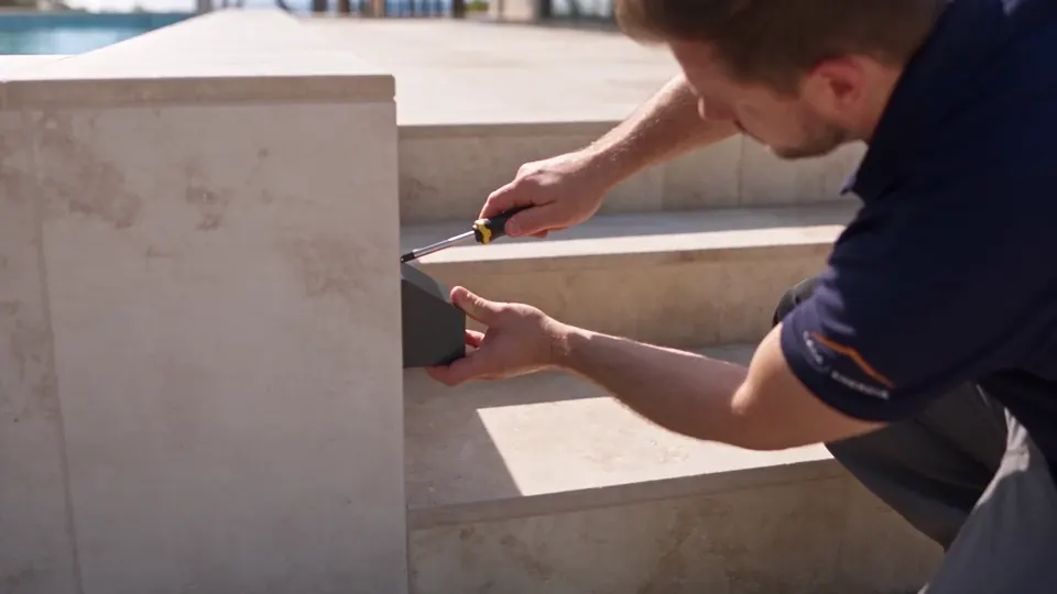 Illustration d’un technicien installant un éclairage autour d’une piscine